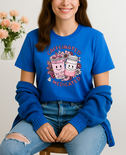 Woman wearing blue Caffeinated and Medicated graphic T-shirt with cute drink and pill bottle design, handmade organic cotton fun fashion tee