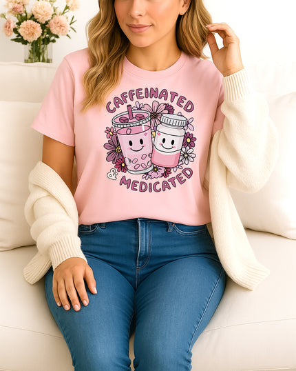 Woman wearing pink Caffeinated and Medicated graphic T-shirt with cute drink and pill bottle design, handmade organic cotton fun fashion tee
