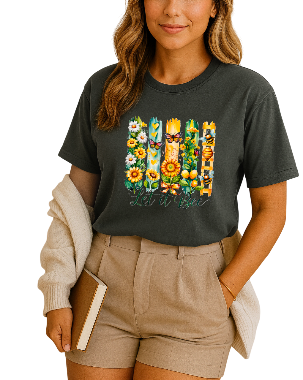 Woman wearing a black t-shirt with floral and butterfly design, holding a book.