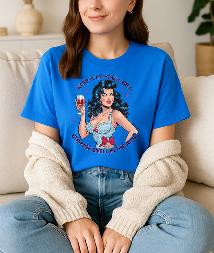 Woman wearing blue retro pin-up graphic T-shirt with Keep It Up You’ll Be a Strange Smell in the Attic text, handmade organic cotton edgy fashion tee