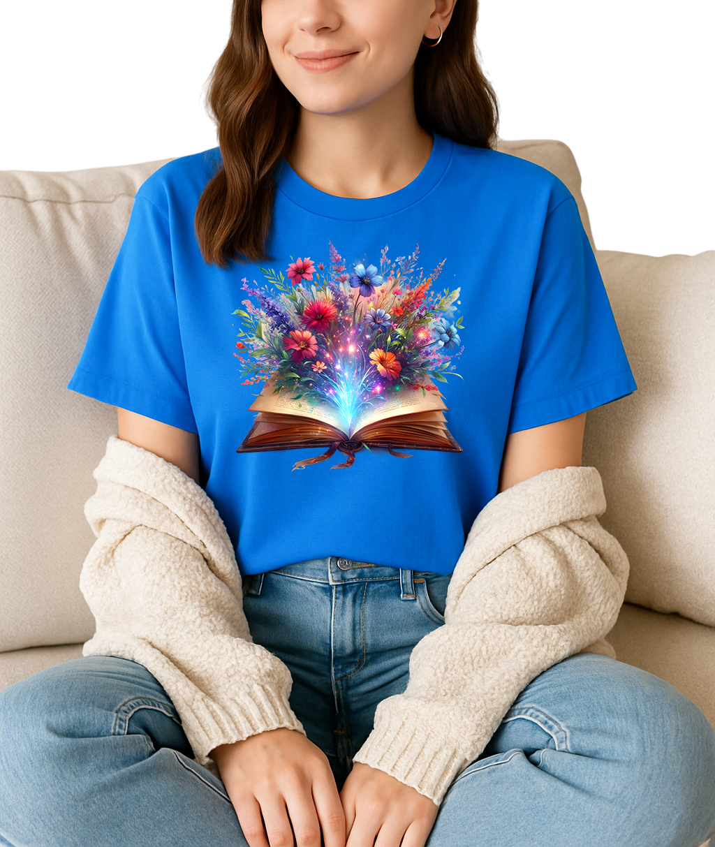 Person wearing a blue t-shirt with a colorful floral design on a book, sitting on a beige couch.