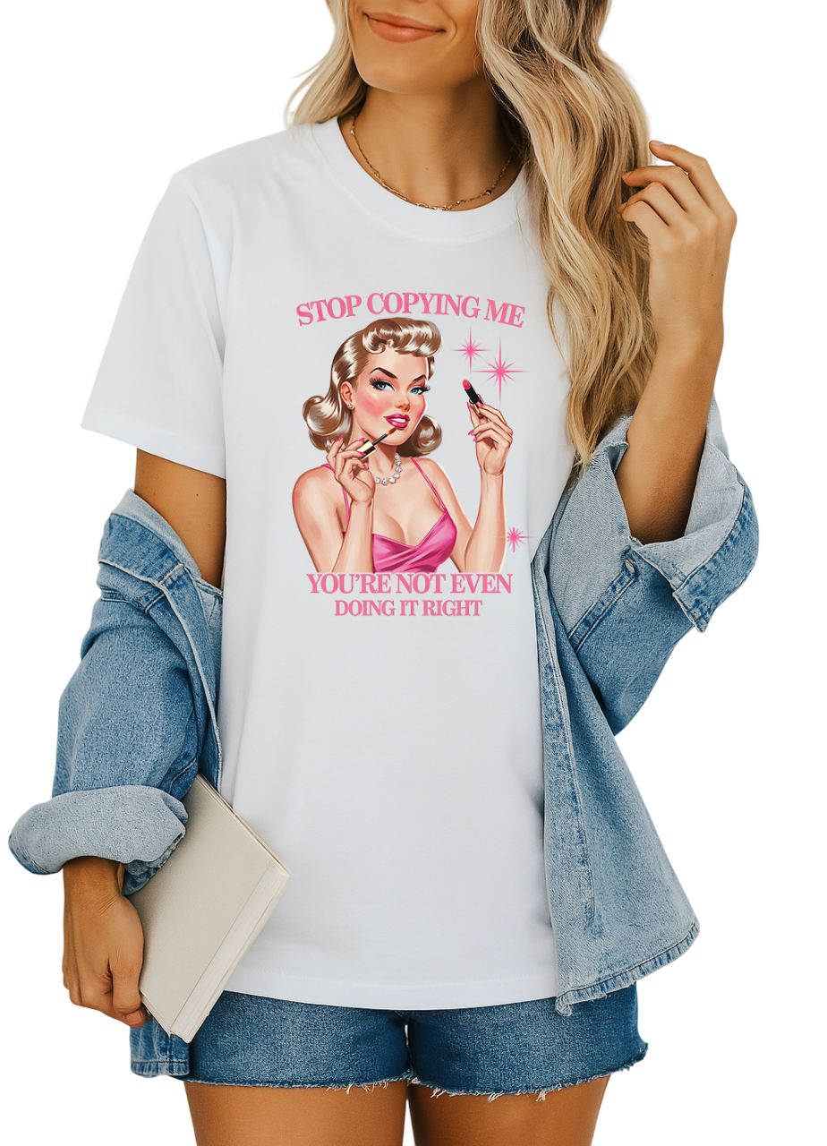 Person wearing a white t-shirt with a graphic design and text, paired with a denim jacket and shorts.