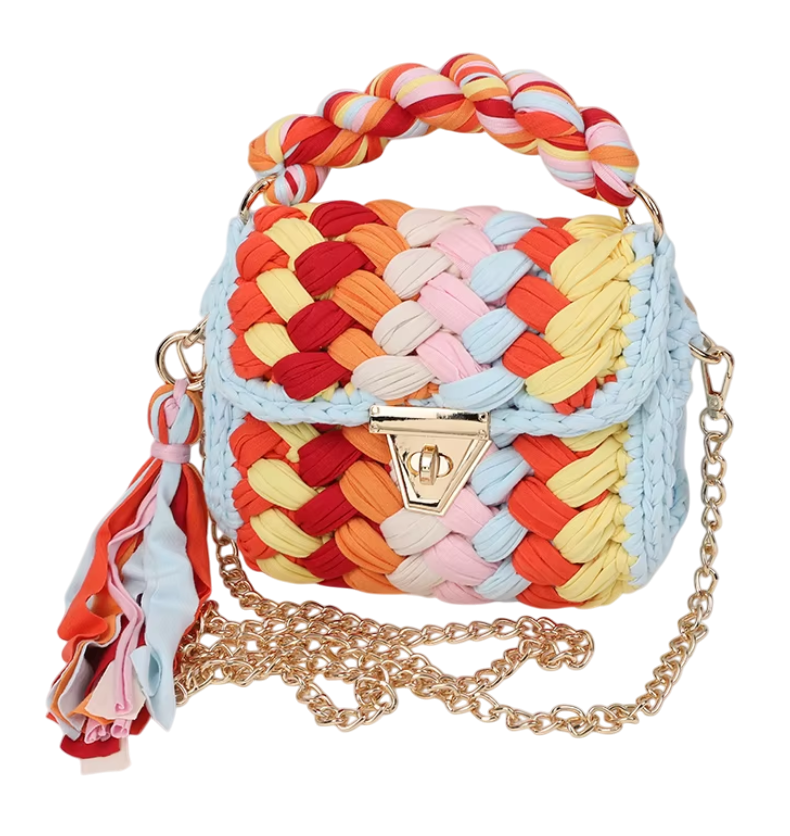 Colorful woven handbag with braided handle and gold chain strap on a white background