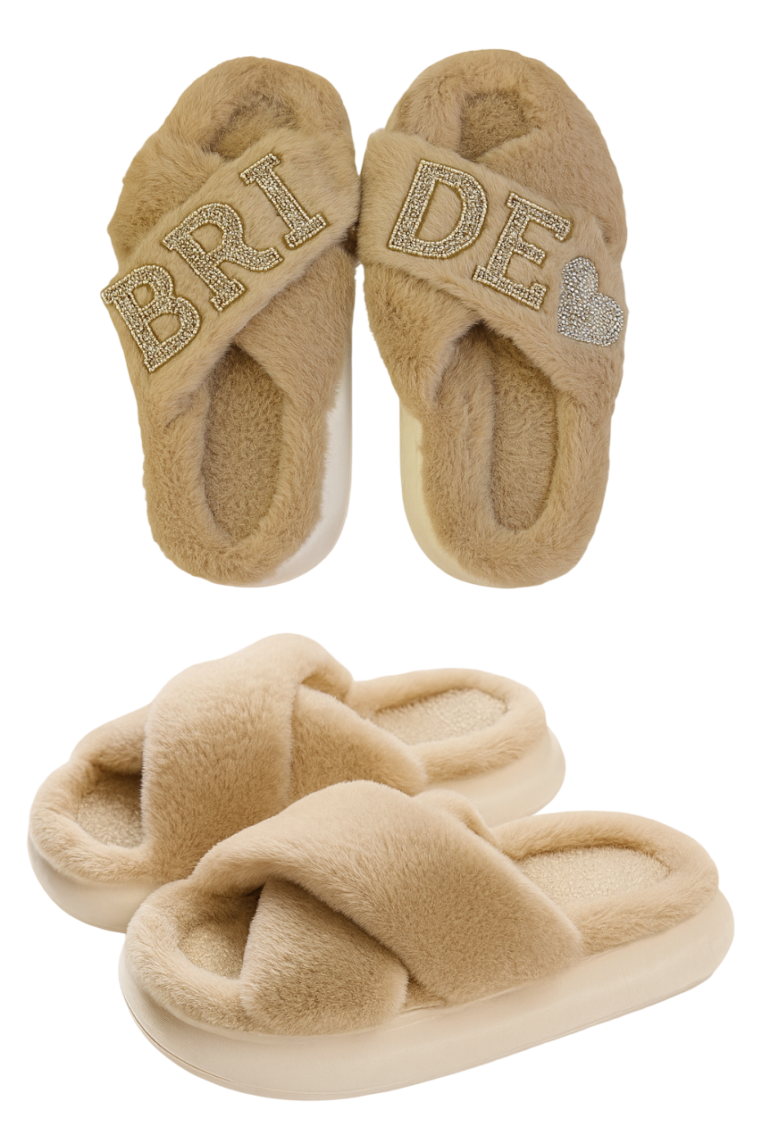 Pair of beige slippers with 'Bride' and heart designs on a white background
