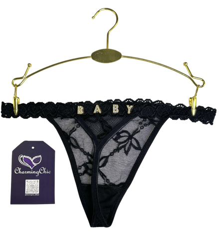 Black lace thong on a gold hanger with 'Charming Chic' tag.