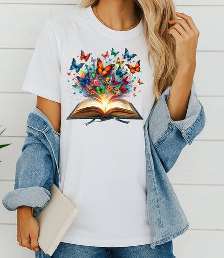 Person wearing a white t-shirt with a colorful butterfly design and an open book, standing against a white background.