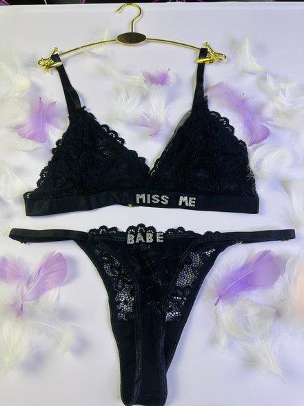 Black lace lingerie set with 'Miss Me' and 'Babe' text on a white background with purple flowers.