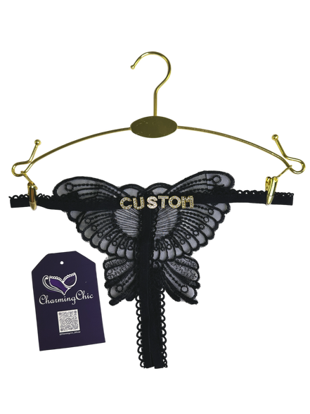 Black butterfly-shaped lace lingerie on a gold hanger with 'Custom' text, CharmingChic tag visible.
