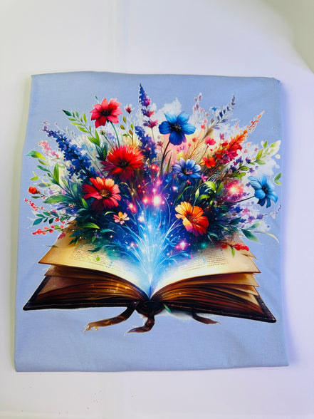 Open book with colorful floral design on a light blue background