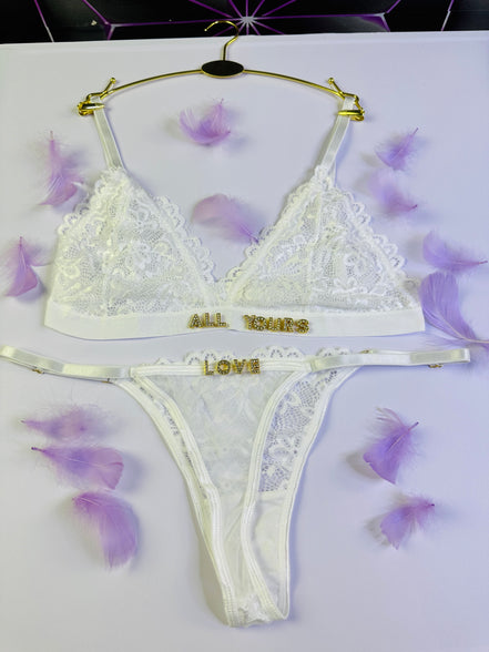 White lace lingerie set with 'All Yours Love' text on a white background with purple flowers.