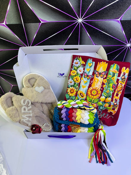 Gift box with slippers, colorful bag, and cards against a geometric-patterned background