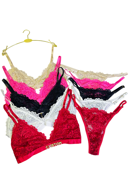 Set of colorful lace lingerie on hangers against a white background
