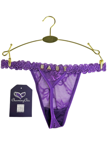 Purple lace thong with 'BABY' lettering on a gold hanger against a white background.